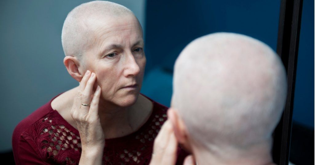 Mature Woman Looking at Her Face in Mirror