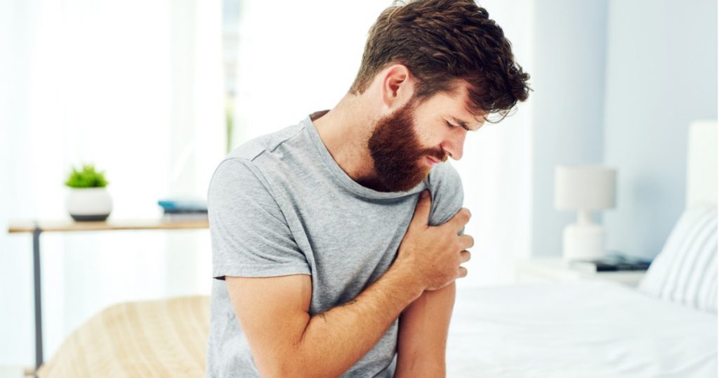 Young Adult Man Holding His Arm in Pain