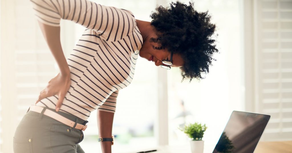 Woman Hunched Over in Pain Holding Back