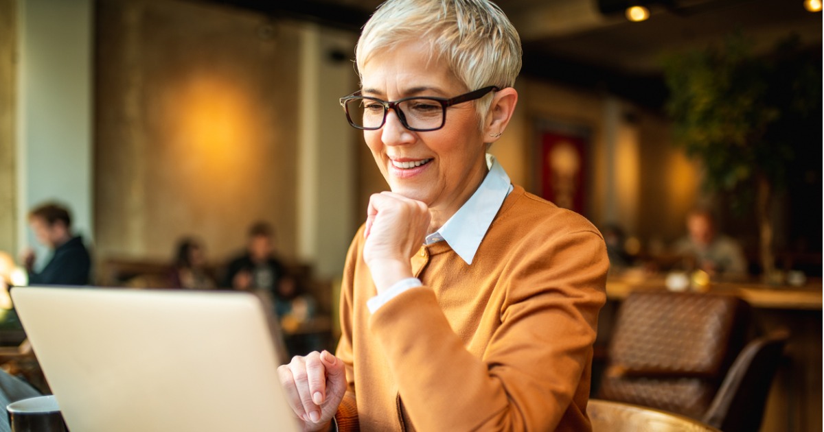 Senior Business Woman Filling Out Form on Computer